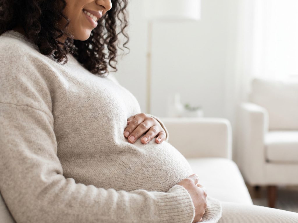 Pregnant woman receiving support for prenatal chiropractic care and pregnancy wellness
