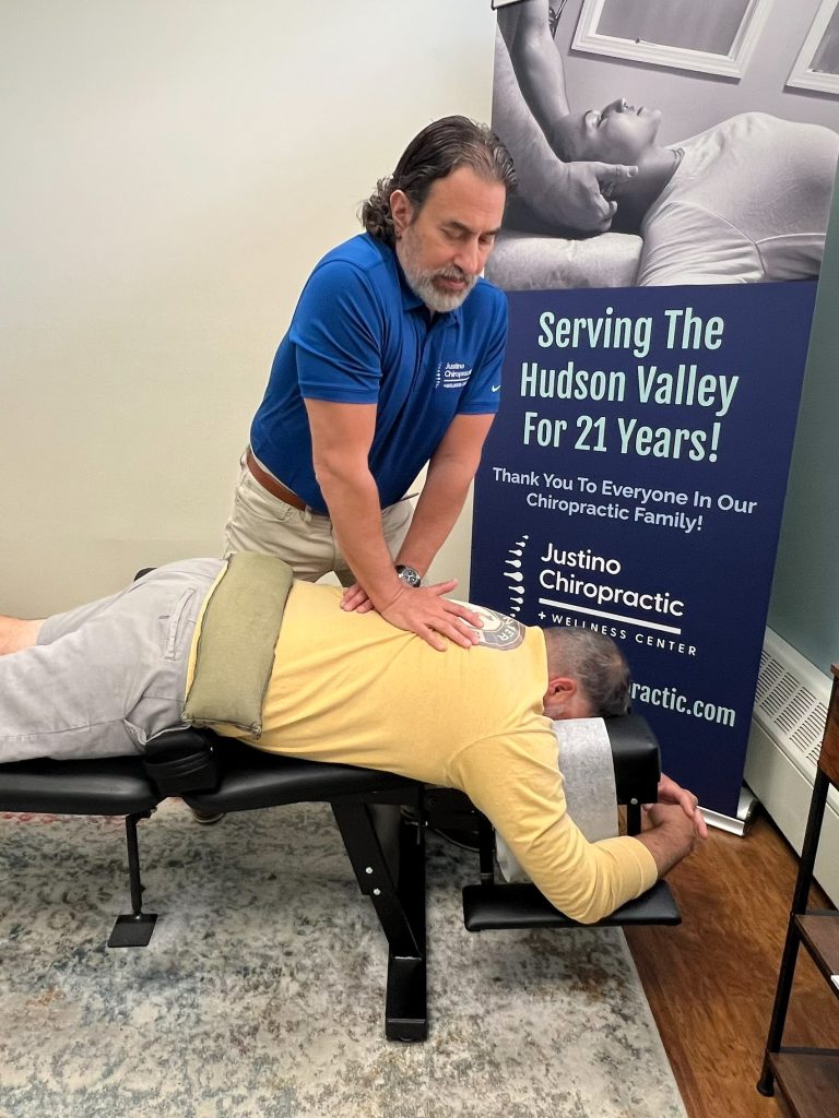 Dr. Vincent Justino performing a chiropractic adjustment to help improve spinal mobility and reduce discomfort