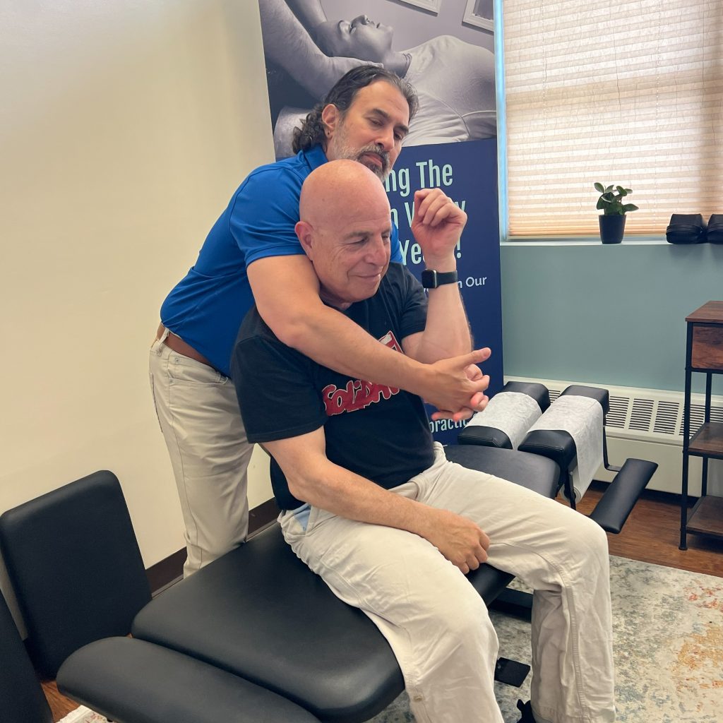 Dr. Vincent Justino performing a hands-on chiropractic adjustment to help improve mobility and reduce discomfort